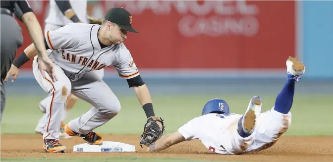  ??  ?? LOS ANGELES: Second baseman Joe Panik #12 of the San Francisco Giants tags out Austin Barnes #15 of the Los Angeles Dodgers attempting to steal second in the eighth inning at Dodger Stadium on Friday in Los Angeles, California. The Dodgers won 6-4.—