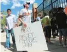  ?? BALTIMORE SUN KIM HAIRSTON/ ?? Brendan Hurson, 37 at the time, a public defender who took the day off, holds a sign that says “Don’t Forget Freddie Gray” as he stands with other fans outside Oriole Park at Camden Yards in 2015.