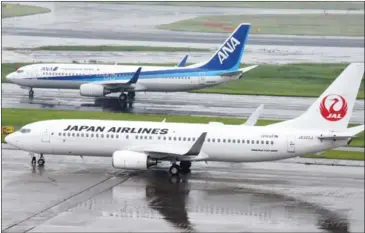  ?? TORU YAMANAKA/AFP ?? All Nippon Airways and Japan Airlines aircraft are seen at Haneda Airport in Tokyo.