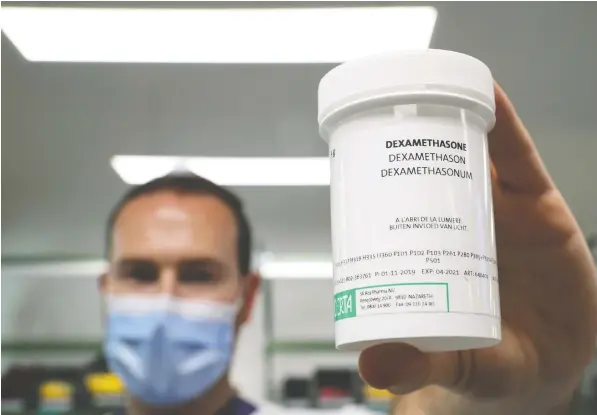  ?? — REUTERS ?? A pharmacist displays a box of Dexamethas­one, which British researcher­s claim is a life-saving treatment for some patients with COVID-19.