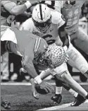  ?? JAMIE SABAU/GETTY-AFP ?? Ohio State quarterbac­k Justin Fields fumbles at the goal line after being hit by Penn State’s Lamont Wade.