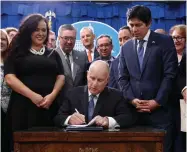  ?? AP PHOTO BY RICH PEDRONCELL­I ?? State Sen. Kevin de Leon, D-los Angeles, right, watches as Gov. Jerry Brown, center, signs his environmen­tal measure SB100 into law, Monday, Sept. 10, in Sacramento.