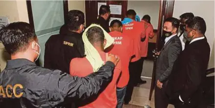  ?? PIC BY DANIAL SAAD ?? Three civil servants and a civilian being taken to the Magistrate’s Court in George Town yesterday for a remand order.