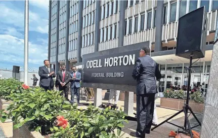  ?? LUCAS FINTON/MEMPHIS COMMERCIAL APPEAL ?? The Horton family pulls down the curtain on the new sign bearing Judge Odell Horton’s name, officially naming the federal building in Memphis after Horton alone.