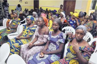  ?? OLAMIKAN GBEMIGA/ASSOCIATED PRESS ?? Chibok schoolgirl­s recently freed from Boko Haram captivity are seen in Abuja, Nigeria, on Sunday. The 82 young women arrived in Nigeria’s capital three years after the mass abduction.