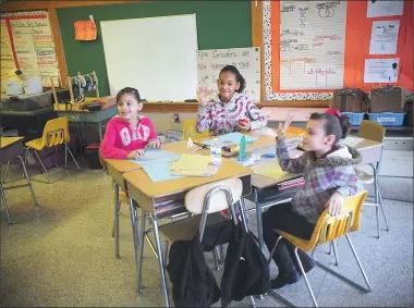  ?? Photos by Ernest A. Brown ?? Issis Vazquez, 9, Vrithny Colon, 10, and Jinoska Sanchez-Burgas, also, 10, from left, 4th grade ESL students at Kevin Coleman Elementary School in Woonsocket, greet the state commission­er of education during his visit to the school on Thursday.