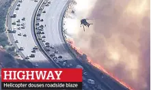  ??  ?? HIGHWAY Helicopter douses roadside blaze
