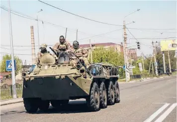  ?? LYNSEY ADDARIO/THE NEW YORK TIMES ?? Ukrainian fighters roll through Kramatorsk on Friday in Ukraine’s eastern Donbas region.