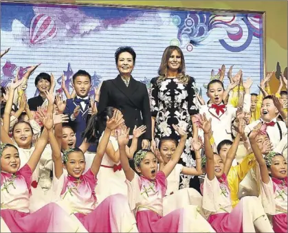  ?? POOL / GREG BAKER ?? Peng Liyuan y Melania Trump posan con los alumnos del colegio de primaria Ban Chang de Pekín.