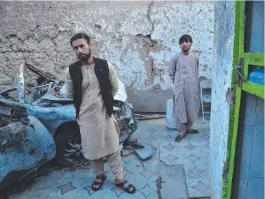  ?? Picture: AFP ?? Relative of one of the dead stands next to the car hit in a US drone strike in Kabul.
