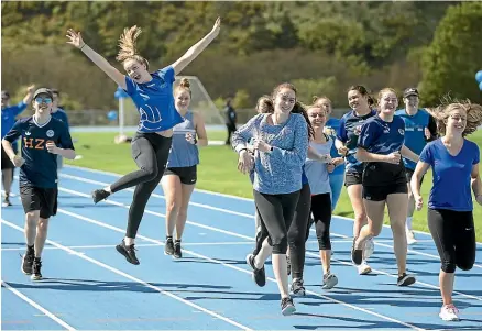  ?? MURRAY WILSON/STUFF ?? Massey student Rebecca Gibbs jumps for joy while doing a group run for Blue September.