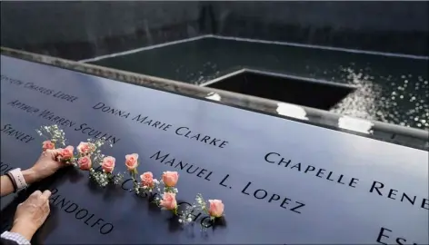  ?? AP Photo/John Minchillo ?? In this Sept. 11, 2020, file photo, mourners place flowers in the name cut-out of Kyung Hee (Casey) Cho at the National September 11 Memorial and Museum in New York.