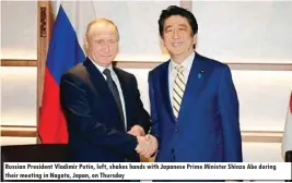  ??  ?? Russian President Vladimir Putin, left, shakes hands with Japanese Prime Minister Shinzo Abe during their meeting in Nagato, Japan, on Thursday