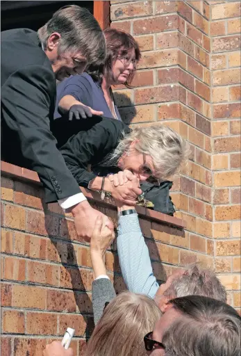  ??  ?? The parents of murdered Stellenbos­ch student Hannah Cornelius shake hands with friends after the memorial service for their daughter at the Fish Hoek Dutch Reformed church yesterday.