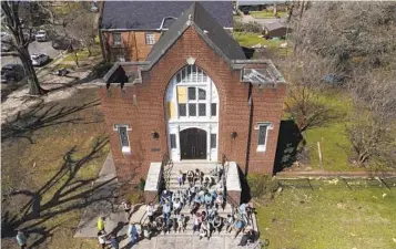  ?? JULIO CORTEZ AP ?? People worship on the steps of the Rolling Fork United Methodist Church in Mississipp­i on Sunday as damage from Friday’s tornado is visible around the property. At least 25 people were killed in the storm.