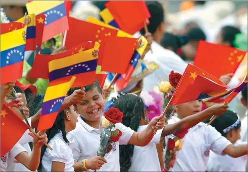  ?? JORGE SILVA / REUTERS ?? Venezuelan children wave flags as they welcome President Xi Jinping at Simon Bolivar airport in Caracas on Sunday.