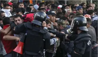  ?? MARKO DJURICA/REUTERS ?? Hungarian police fired tear gas at frustrated migrants demanding entrance to Hungary from Serbia on Wednesday.
