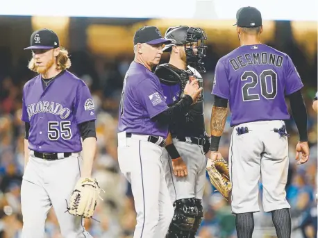  ?? Alex Gallardo, The Associated Press ?? Rockies starting pitcher Jon Gray, left, walks off the mound after being pulled by manager Bud Black, who confers with catcher Drew Butera and first baseman Ian Desmond during the third inning Monday night at Dodger Stadium.