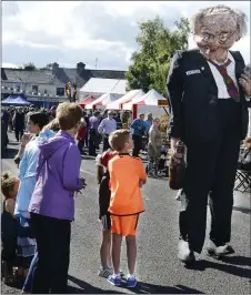  ??  ?? Looking up to a four eyed giant at the Old Fair in Tubbercurr­y last year. Pic: Tom Callanan.