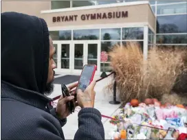  ?? CHRIS SZAGOLA — THE ASSOCIATED PRESS ?? Michael Briggs of Philadelph­ia takes a photo at a small memorial left in remembranc­e to Kobe Bryant at the entrance of the Bryant Gymnasium at Lower Merion High School, Monday in Wynnewood, Pa. The 41-year-old Bryant and his 13-year-old daughter, Gianna, were among nine people who died in the crash in Calabasas in foggy weather conditions Sunday morning.