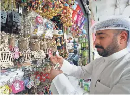  ?? YASSER AL-ZAYYAT/AFP VIA GETTY IMAGES ?? A Kuwaiti man checks Ramadan decoration­s in a shop in Kuwait City on Wednesday, a day before the start of the Muslim holy month. During Ramadan, Muslims refrain from eating, drinking, smoking, and sexual intercours­e from sunrise until sunset.