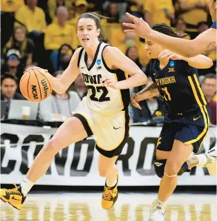  ?? CHARLIE NEIBERGALL/AP ?? Iowa guard Caitlin Clark tries to drive past West Virginia guard JJ Quinerly, a Norfolk native, during Monday night’s second-round NCAA Tournament game in Iowa City.