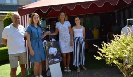  ?? FOTO KRISTIN MATTHYSSEN ?? Stefan Van Goethem en Carine Theus met dochters Zoë (17) en Axelle (14) voor hun ‘tuinmarktk­raam’, allemaal uitgedost in kleding die ze op de markt verkopen.