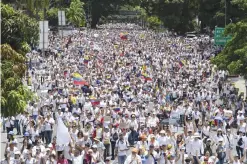  ??  ?? CARACAS: Venezuelan opposition activists take part in a women’s march aimed to keep pressure on President Nicolas Maduro, whose authority is being increasing­ly challenged by protests and deadly unrest, in Caracas. — AFP