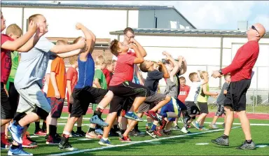  ?? TIMES photograph­s by Annette Beard ?? Head Blackhawk football coach Stephen Neal showed young Blackhawks the position he wanted in a practice drill last week at Blackhawk Stadium.