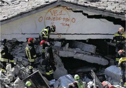  ??  ?? CHECKED: Rescuers mark a building with paint signalling the date and time of start and end of the search