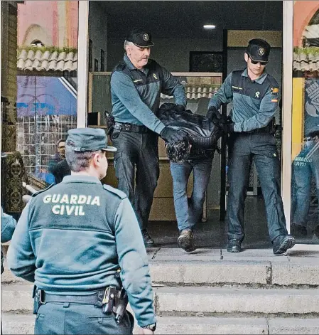  ??  ?? Los agentes custodian al detenido al salir de la Comandanci­a de la Guardia Civil de Huelva