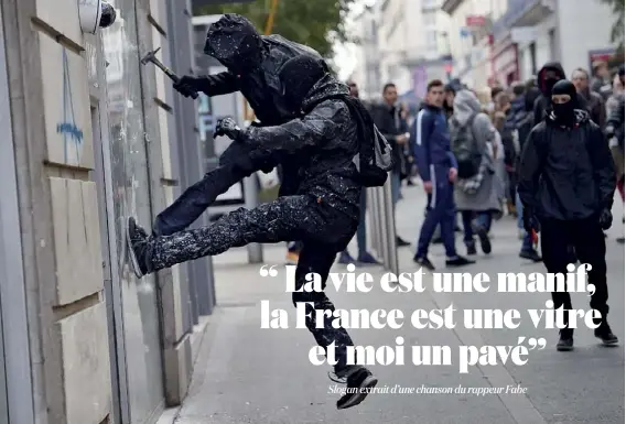  ??  ?? Nantes, le 17 mars. Des casseurs tentent de briser la vitrine d’une banque, pendant une manifestat­ion contre la loi Travail.