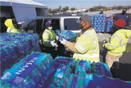  ?? David J. Phillip / Associated Press ?? Volunteers distribute free bottled water to Houston motorists at a drivethrou­gh aid center set up at a stadium parking lot.