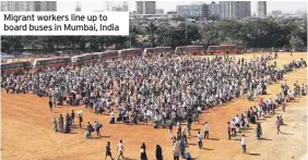  ??  ?? Migrant workers line up to board buses in Mumbai, India