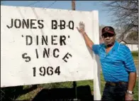  ?? Arkansas Department of Parks and Tourism/a.c. “CHUCK” HARALSON ?? Harold Jones, a third-generation barbecue pitmaster, shows off his street-side sign.