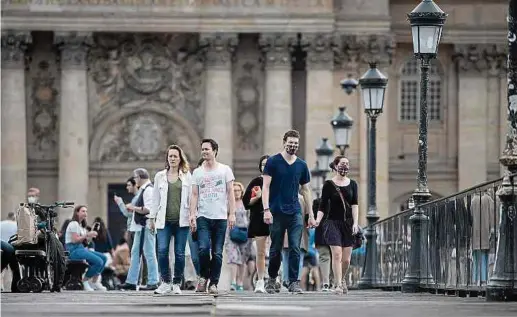  ?? Photos: AFP ?? Des promeneurs sur le pont des Arts à Paris. La France vivait hier son 55e et dernier jour de confinemen­t avant une libération partielle et contrôlée, dans la crainte d’un relâchemen­t excessif qui provoquera­it un rebond de la pandémie.