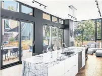  ??  ?? A large marble island is the focal point of the spacious, light-filled kitchen, which opens onto the living room.