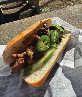  ?? (The Sentinel-Record/Bryan Rice) ?? The Pho House’s grilled beef banh mi sandwich by the creek at Gulpha Gorge Nov. 27 for an episode of Takeout Takeaways.