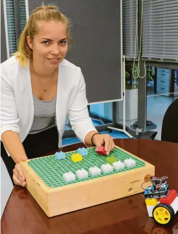  ?? Foto: Julian Würzer ?? Jana Seemann präsentier­t ihr Projekt „Tinker Bricks“. Setzt sie einen Baustein auf die Platte, dann beginnt das Fahrzeug (vorne rechts) entweder zu fahren oder leuchtet.