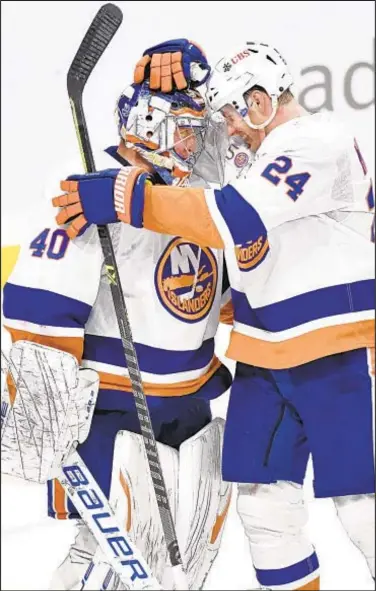  ?? AP ?? Isles congratula­te goaltender Semyon Varlamov after shutout victory Sunday afternoon in Winnipeg.