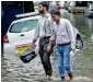  ?? PTI ?? People walking through the water logged street in Mumbai. Heavy rains lashed Mumbai causing waterloggi­ng in several low-lying areas. —