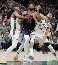  ?? — AFP photo ?? Joel Embiid (centre) of the Philadelph­ia 76ers works against Serge Ibaka (left) and Giannis Antetokoun­mpo of the Milwaukee Bucks during the second half of a game at Fiserv Forum in Milwaukee, Wisconsin.