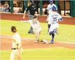  ??  ?? The ball gets by the Padres’ Eric Hosmer as the Dodgers’ Cody Bellinger is safe at first base. A run scored to tie the game in the fifth inning.