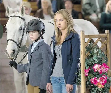  ?? Andrew Bako ?? Alisha Newton (Georgie), left, holds Phoenix’s bridle in a scene with Amber Marshall (Amy) from CBC’s Heartland series.