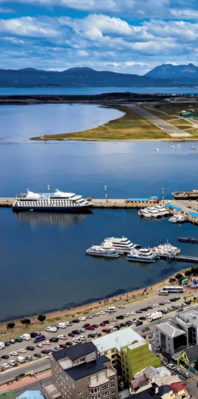  ??  ?? Orizzonti lontani
La baia e il porto turistico di Ushuaia, con alle spalle l’aeroporto, le vette del ghiacciaio Martial e i confini orientali del Parco Nazionale Terra del Fuoco.