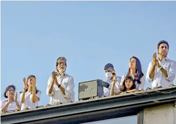  ?? — PTI ?? Bollywood actor Amitabh Bachchan claps as a gesture to show gratitude to the helpers and medical practition­ers who are working relentless­ly to fight coronaviru­s along with family members in Mumbai on Sunday.