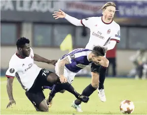  ?? AP PHOTOS ?? AC Milan’s Franck Kessie (left) teammate Ignazio Abate (right) and Austria Vienna’s Christoph Martschink­o (centre) challenge for the ball during the Europa League Group D at the Ernst Happel Stadium in Vienna, Austria. AC Milan won 5-1.