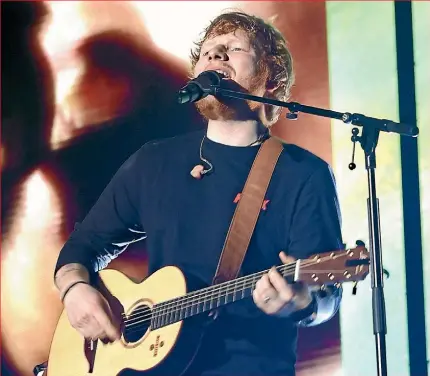  ??  ?? Ed Sheeran takes the stage in a soggy Auckland last night – the heart-throb pop star had earlier been welcomed with a po¯whiri at Mt Smart Stadium.