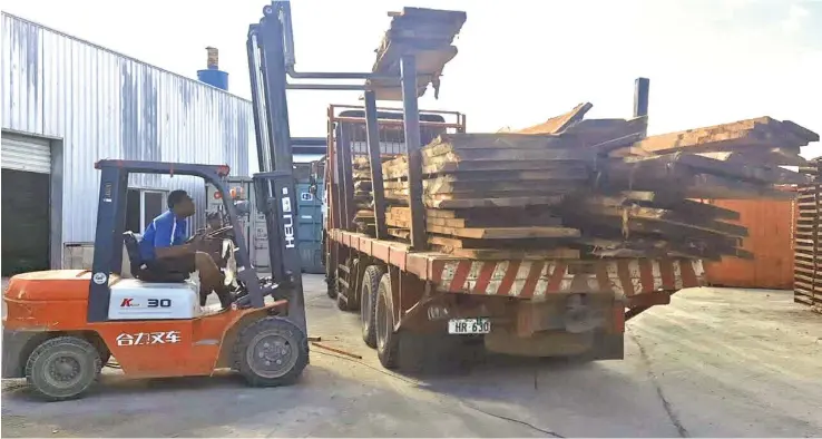  ?? ?? Touchwood Sawmillers Pte Ltd containers are being loaded for export to Japan.