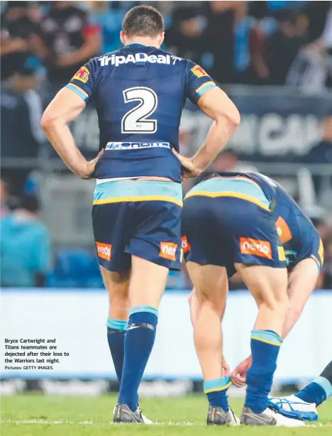  ?? Pictures: GETTY IMAGES ?? Bryce Cartwright and Titans teammates are dejected after their loss to the Warriors last night.